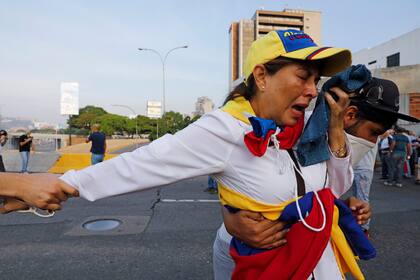 Una mujer escapa de los gases durante la liberación de Leopoldo López