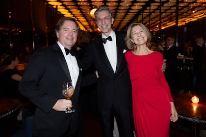 Leopoldo Montes (arquitecto y compañero de Iturrioz desde hace 27 años) junto a Agustín Etchebarne (director de la Fundación LIbertad y Progreso) y la artista plástica, María Noel, con un vestido rojo de Valentino.