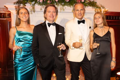 Leopoldo Montes y Javier Iturrioz rodeados por sus sobrinas O'Toole, Inés y Carolina, después de soplar las velitas y brindar.