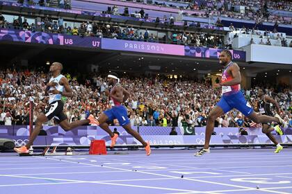 Letsile Tebogo curza la meta primero, delante de Kenneth Bednarek y Noah Lyles en la final de los 200 metros masculinos de París 2024, en el Stade de France de Saint Denis.