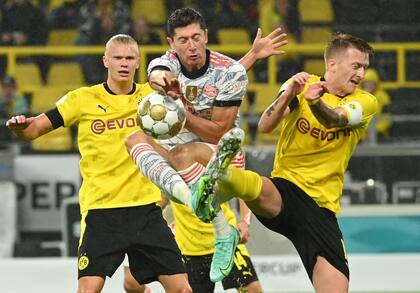 Lewandowski y Reus disputan la pelota en la intensa final que Bayern Munich le ganó a Borussia Dortmund; atrás, Haaland