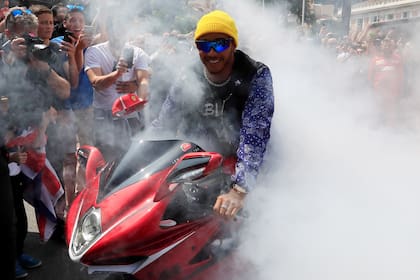 Lewis Hamilton en una motocicleta en la zona de aficionados.