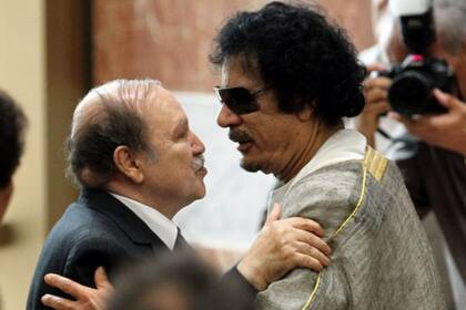 Líder libio Muamar el Gadafi (der.) abraza presidente argelino Abdelaziz Buteflika (izq.) durante sesión extraordinaria de la Liga Árabe en octubre de 2010