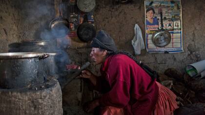 Lilian Ávila Díaz enciende su estufa de leña para preparar el almuerzo para su familia en Coata, un pequeño pueblo a orillas del lago Titicaca, en la región de Puno, Perú