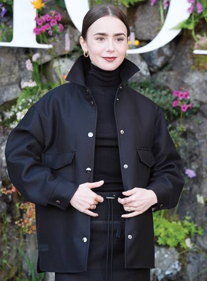 Lily Collins apostó al total black con polera y campera de lana y seda.
