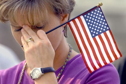 Linda Barrett inclina la cabeza en un minuto de silencio en homenaje a las víctimas del atentado a las Torres Gemelas, el viernes 14 de septiembre de 2001