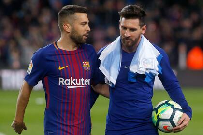 Lionel Messi se lleva la pelota tras un nuevo hat-trick. Lo saluda Jordi Alba