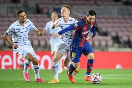 Messi intenta dejar atrás a dos jugadores de Dinamo Kiev; se le sigue negando el gol de jugada