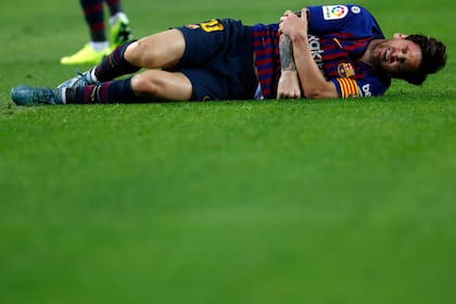 Lionel Messi, dolorido después de doblarse el codo derecho.