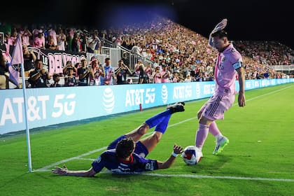 Lionel Messi busca la pelota junto a un banderín, mientras Ignacio Rivero cae al marcarlo.
