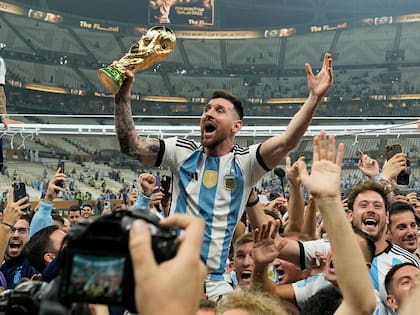 Lionel Messi celebra con la Copa del Mundo ante los hinchas tras ganar la final ante Francia, en el estadio Lusail