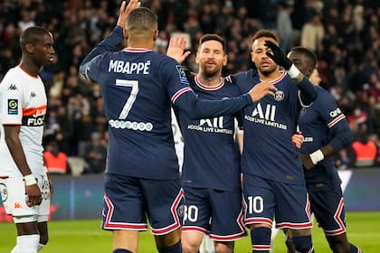 Lionel Messi (centro) celebra con Neymar (derecha) y Kylian Mbappé tras anotar el cuarto gol del Paris Saint Germain en la victoria 5-1 ante Lorient en la liga francesa, el domingo 3 de abril de 2022