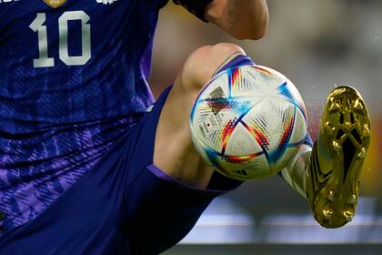Lionel Messi, con sus botines dorados y la pelota Al Rihla, que se usará en el Mundial de Qatar
