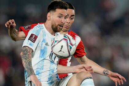 Lionel Messi controla la pelota y lo marca Miguel Almirón