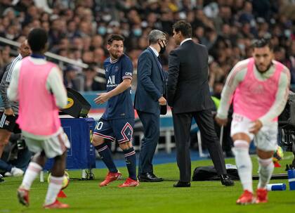 Lionel Messi del PSG mira al entrenador en jefe del PSG, Mauricio Pochettino, luego de que fuera sustituido durante el partido de fútbol de la Liga Uno francesa entre Paris Saint-Germain y Lyon en el Parc des Princes en París el domingo 19 de septiembre de 2021.