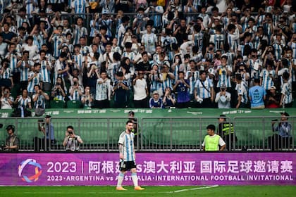 Lionel Messi en el partido ante Australia; de fondo, la multitud de hinchas chinos que alentaron a la selección argentina