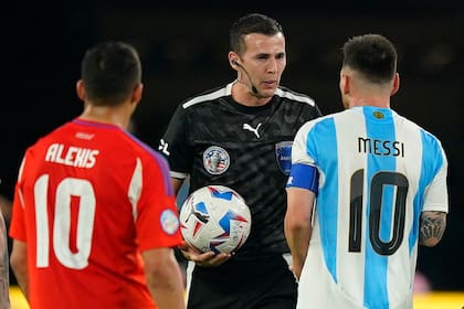 Lionel Messi habla con el árbitro uruguayo Andrés Matonte luego del final del primer tiempo del partido que disputan las selecciones de Chile y Argentina, por la Copa América 2024 en el MetLife Stadium, New Jersey, el 25 de junio de 2024.