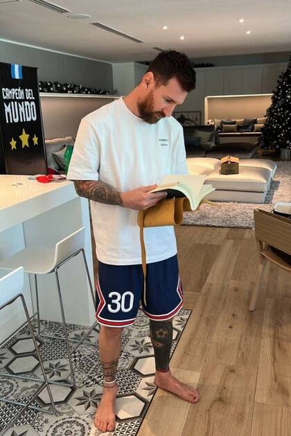 Lionel Messi lee el libro de firmas que le entregaron los vecinos del club de campo Kentucky, en Funes, afueras de Rosario