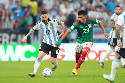 Lionel Messi lucha por la pelota con Jesús Gallardo durante el partido que disputan Argentina y México, por la primera fase de la Copa del Mundo Qatar 2022 en el estadio Lusail, Doha, el 26 de Noviembre de 2022.