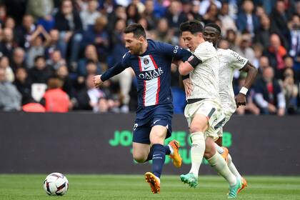 Lionel Messi lucha por la pelota con Laurent Abergel durante el partido que disputan PSG y FC Lorient; la derrota del domingo cambió el parecer del club sobre su viaje a Arabia Saudita