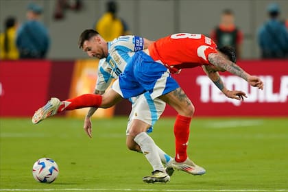 Lionel Messi lucha por la pelota con Rodrigo Echeverría; el crack jugó algo disminuido físicamente