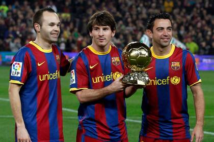 Messi, arropado por Iniesta y Xavi, los cracks que lo rodearon en la época de oro. Aquí, con el Balón de Oro que ganó por su rendimiento en 2011