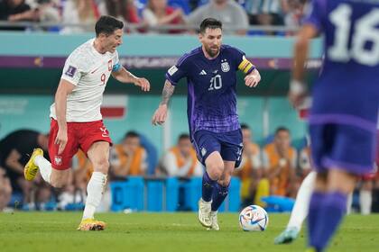 Lionel Messi y Robert Lewandowski disputan la pelota