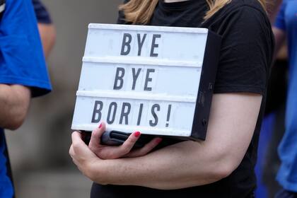 Una mujer sostiene un cartel durante una manifestación en Westminster, antes del anuncio del resultado del Partido Conservador