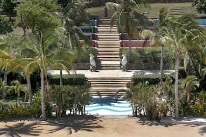 Estatuas de loros junto a las escaleras que conducen a la playa en la propiedad