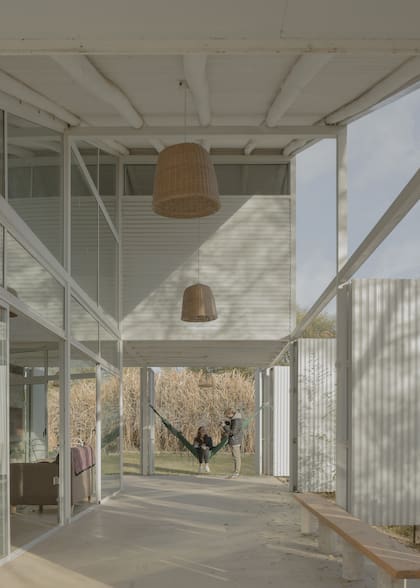 Entre el ingreso y la galería que lleva al asador, se forma un espacio intermedio en forma de L. Gracias a los postigones móviles y a las puertas-ventanas, puede abrirse por completo, formando un todo entre interior y exterior.