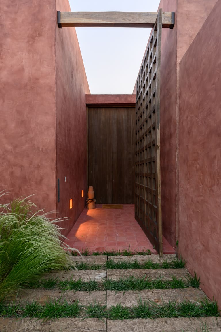 El portón de ingreso en madera maciza de kiri reproduce el patrón cuadriculado de la fachada. Enmarcada por el acabado cementicio pigmentado, la galería se completa con columnas macizas, cielo raso y piso de Laurel, éste último hecho con tablas enteras de distinto ancho.
Fotos: Gonzalo Viramonte