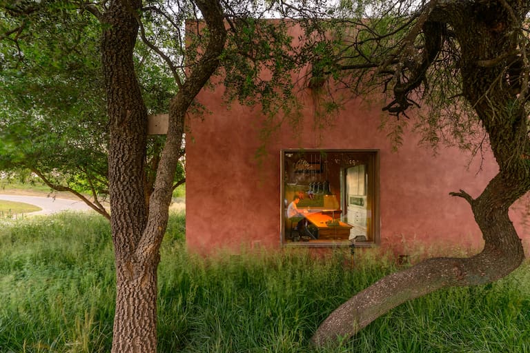 El piso de calcáreo dibuja la geometría rectangular de la piscina alargada para nadar y los senderos delimitan formas circulares de piedra y césped. La única ventana que da al frente se hizo para enmarcar la vista del Chañar.
Fotos: Gonzalo Viramonte