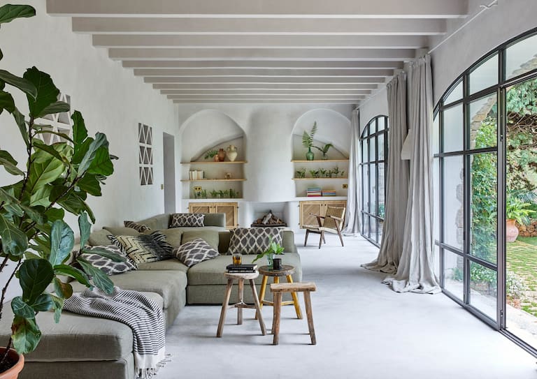 En la galería a la que dan uno de los tres dormitorios y el comedor diario (al fondo), el piso se hizo con el mismo mortero de cal que los del interior, pero acá con un dibujo trazado con piedras del lugar cortadas a mano. Los ambientes tienen grandes ventanales que conectan con la vegetación del jardín en diálogo con las plantas de interior.
Fotos: Greg Cox