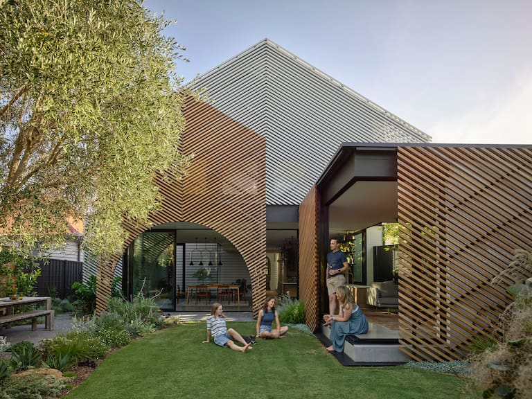 El contrafrente de esta casa australiana se protegió con listones de fresno en blanco y en natural sobre estructuras de aluminio, unificando el terreno ganado al jardín y mimetizándolo con este
Fotos: Gentileza Derek Swalwell / Austin Maynard Architects