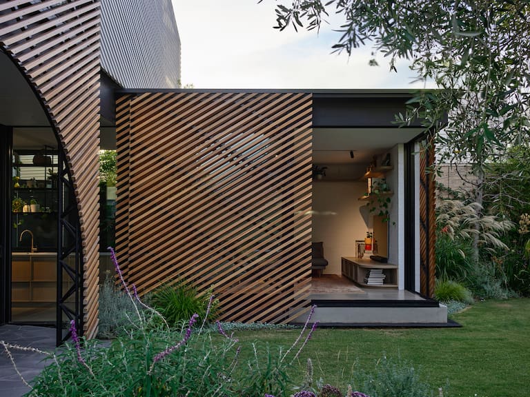 El contrafrente de esta casa australiana se protegió con listones de fresno en blanco y en natural sobre estructuras de aluminio, unificando el terreno ganado al jardín y mimetizándolo con este
Fotos: Gentileza Derek Swalwell / Austin Maynard Architects