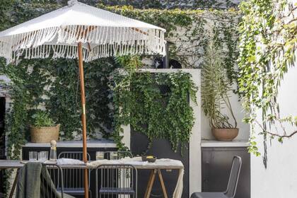 Una sombrilla tejida por la madre del dueño de casa protege la mesa sobre caballetes.