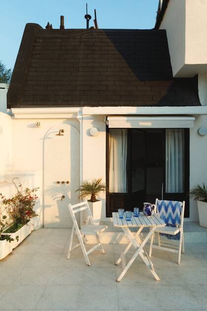 Ducha y grifería (Robinet) amurados al revestimiento de pared tipo terrazo con terminación curva (Monolitic). Juego de mesa y sillas (Easy) y manta (Zara Home). Los toldos están automatizados.