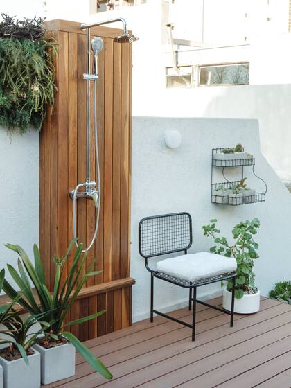Contra un sector revestido de madera en esta otra terraza, ducha y duchador monocomando de FV.