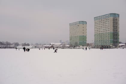 Un grupo de personas camina por el nevado Wanstead Flats, en Londres, el lunes 12 de diciembre de 2022. 