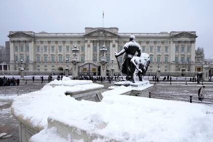 Una estatua afuera del Buckingham Palace, llena de nieve