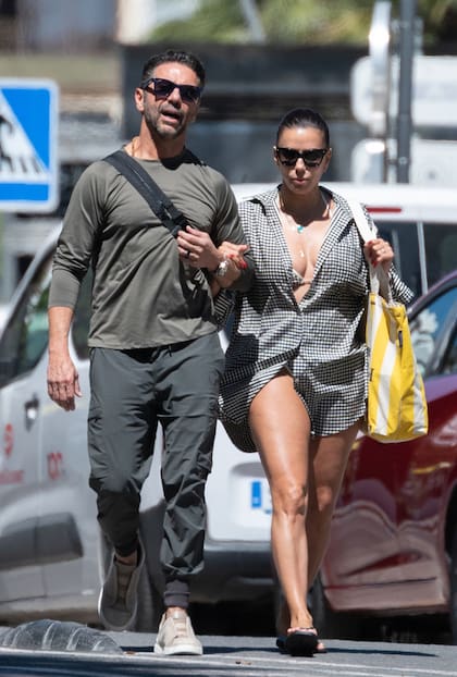 Longoria retirándose del balneario junto a su marido, Pepe Bastón. Mientras que el empresario vistió un look monocromático, la actriz resaltó su outfit playero con un bolso a rayas en amarillo y blanco