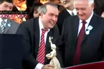 López al momento de recibir la estatuilla del premio "Libertad" ante la atenta mirada de Osvaldo Morelli