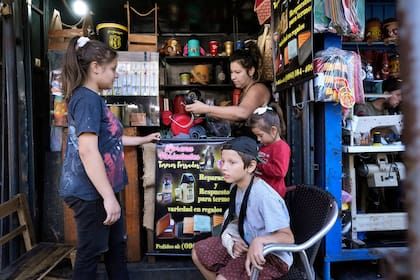 Lorena Ocampos, arriba a la derecha, trabaja en su tienda de termos en el Mercado #4 en Asunción, Paraguay, el sábado 22 de abril de 2023.