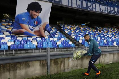Lorenzo Insigne, capitán de el Napoli, deposita un ramo de flores frente a una imagen de Diego Armando Maradona en el San Paolo