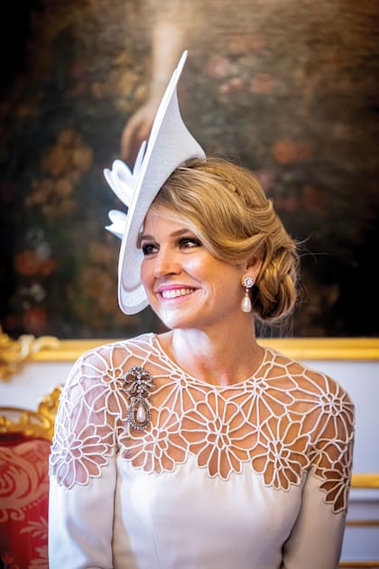 Los accesorios y las joyas son dos claves de los look de la Reina. Acá se la ve con
pendientes y broche de perlas del Cofre de los Orange, y gran tocado de Philip Treacy