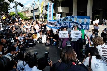 Los activistas sostienen pancartas durante una manifestación frente al Tribunal de Distrito de Tokio, después de que el tribunal absolvió a tres ex funcionarios de la empresa que operaba la planta nuclear de Fukushima