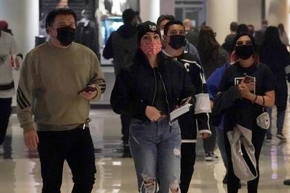 Los aficionados llevan máscaras mientras caminan dentro del Crypto.com Arena antes de un partido de hockey de la NHL  el jueves 6 de enero de 2022, en Los Ángeles, California