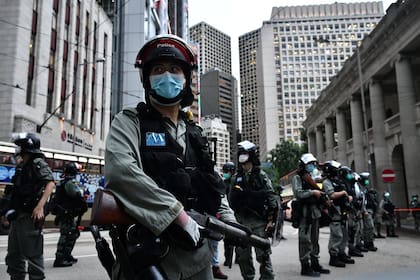 Los agentes de la policía antidisturbios hacen guardia antes de una marcha en favor de la democracia en el distrito central de Hong Kong el 9 de junio de 2020