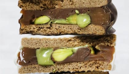 Los alfajores de Camboya de chocolate semiamargo relleno con Nutella, pistachos y dulce de leche; y de chocolate blanco relleno con Nutella, pistachos y dulce de leche