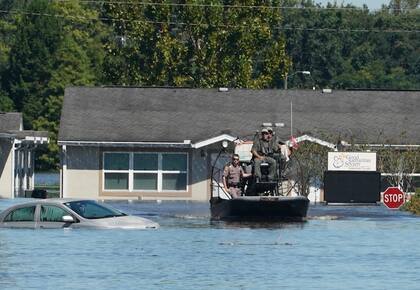 Los alguaciles del condado de Osceola usan una lancha para navegar en las aguas de la inundación que siguió al huracán Ian el viernes en Kissimmee, Florida (Bryan R. Smith/AFP/Getty Images)